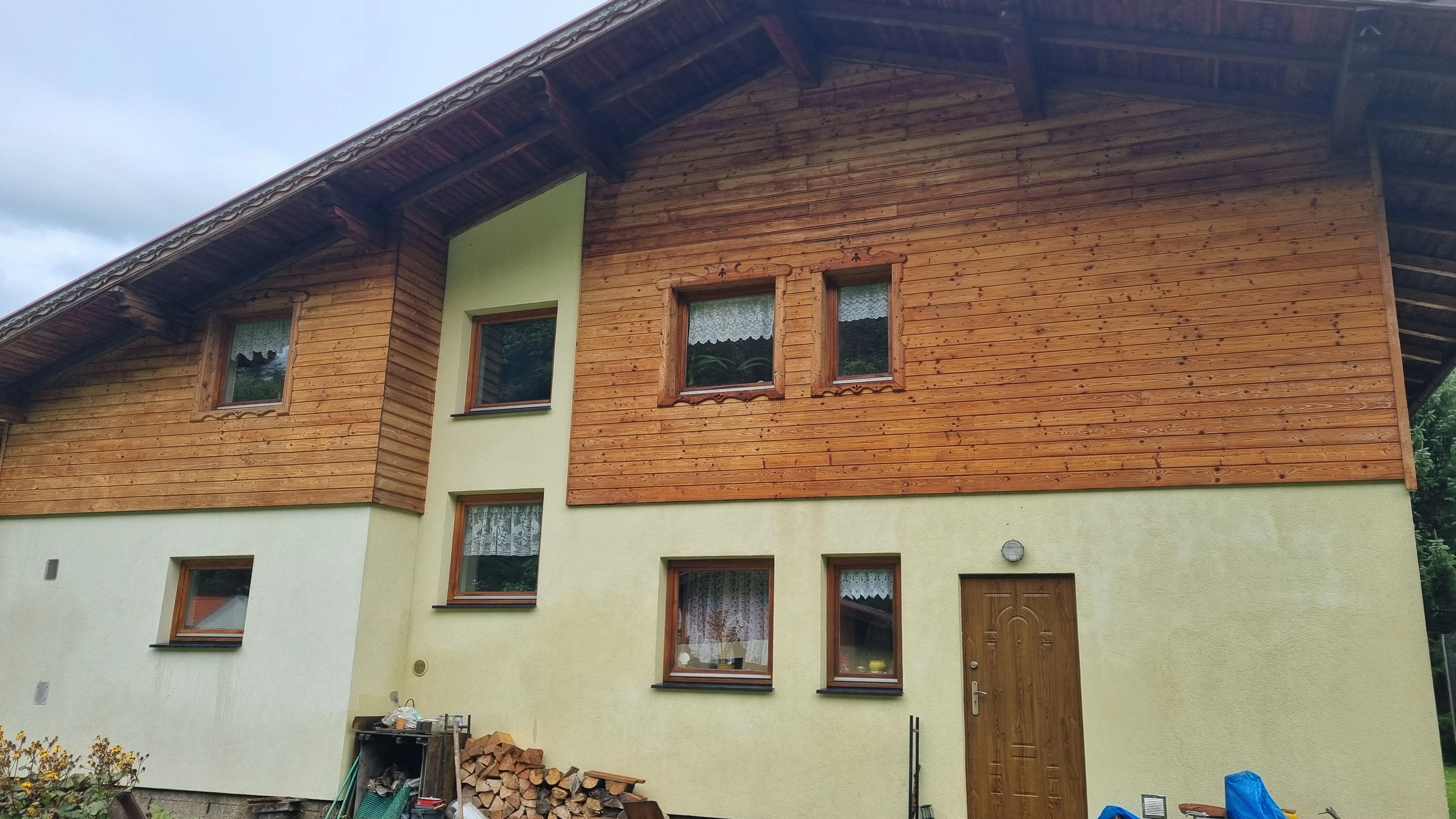 Budynek z drewnianą górną częścią i jasną elewacją