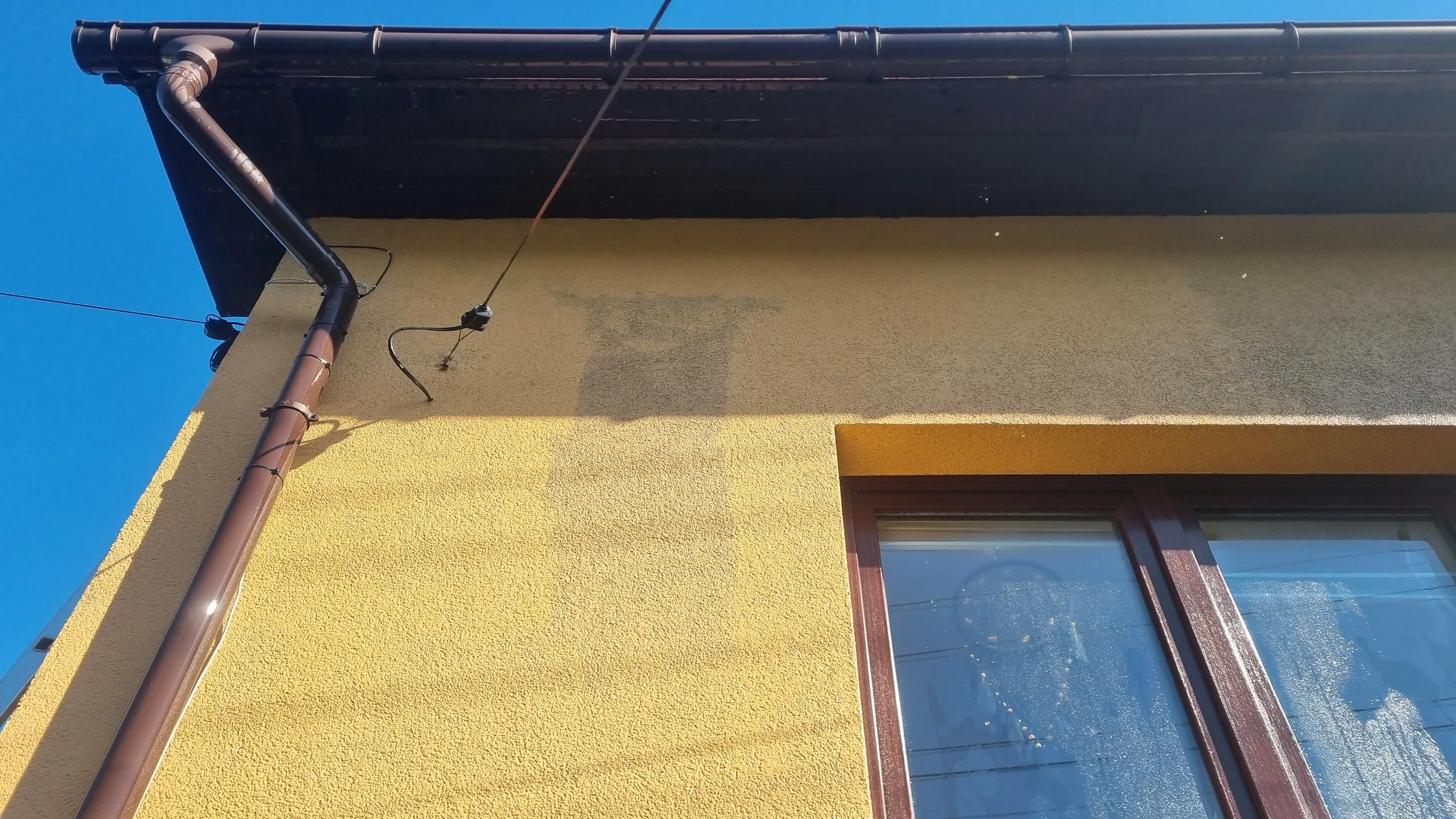Czyszczenie elewacji budynku z widocznymi zaciekami i plamami na tynku